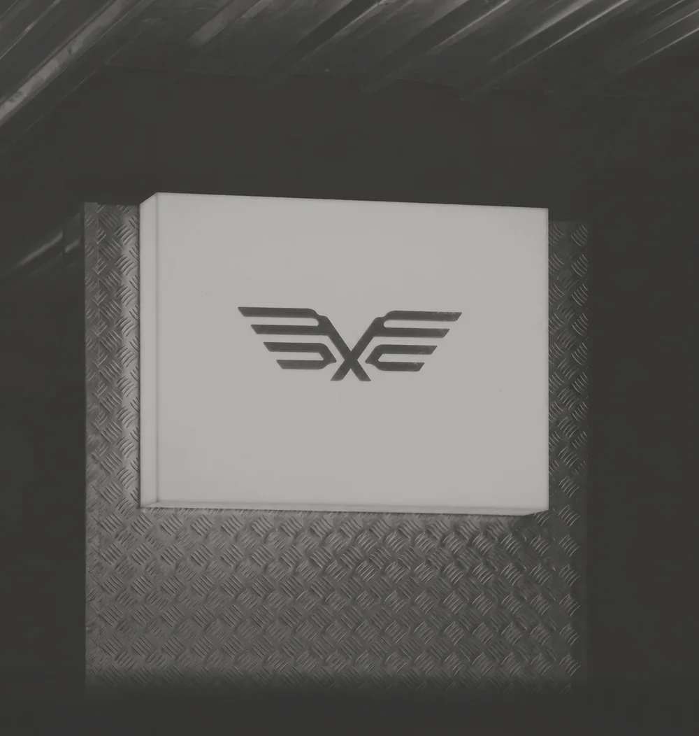 The wing mark alone on an illuminated lightbox at architectural scale.